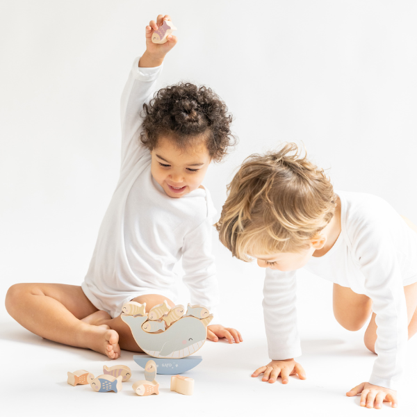 Two children playing with wooden toys on a white background