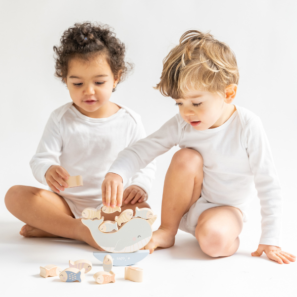 Two children playing with wooden toys on a white background