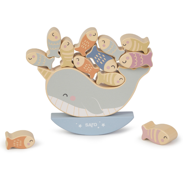 Wooden toy whale with fish on a white background