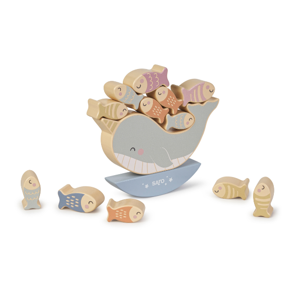 Wooden toy whale with stacked fish on a white background
